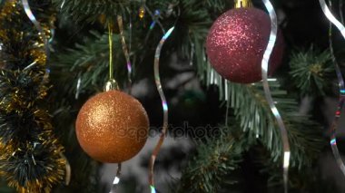 Bir şekilde dekore edilmiş ve ışıklı Noel ağacı güzel parlak bir top ile çok renkli ışıklar bir Garland bulanık. 4k, ağır çekim