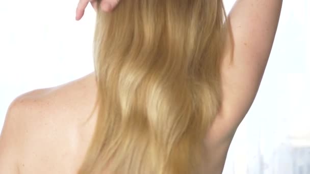 View from behind Beautiful woman with naked back, hair styling. Slow motion. calm attractive girl with long healthy hair. Close it. 4k — Stock Video