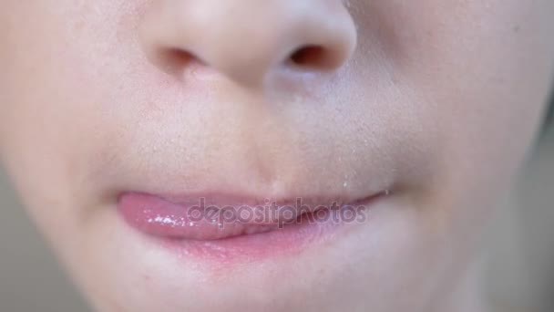 Close-up. a mastigar a boca dos rapazes. 4K. o menino lambe os lábios . — Vídeo de Stock