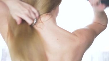 Güzel kadın çıplak sırt, saç şekillendirme ile arkasından görüntüleyin. Ağır çekim. uzun sağlıklı saçları sakin çekici kız. Kapatın. 4k