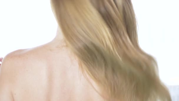 Θέα από πίσω από την όμορφη γυναίκα με γυμνή πλάτη, styling μαλλιών. Αργή κίνηση. ήρεμη ελκυστική κοπέλα με μακρά υγιή μαλλιά. Κλείστε το. 4k — Αρχείο Βίντεο