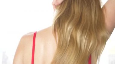 Arkadan Görünüm, yakın çekim, 4 k, ağır çekim. sarışın bir kadın sutyen askısı ile bir omuz kapalı alır.