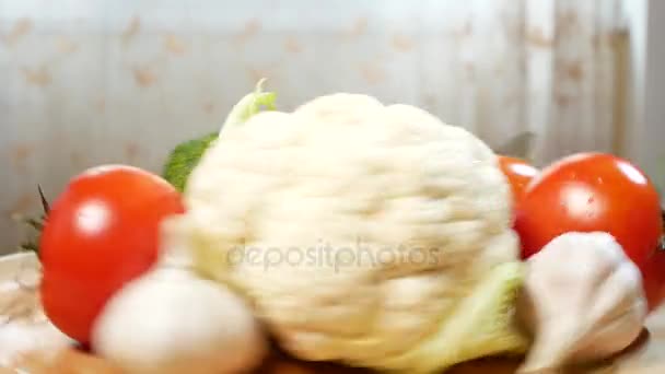 Цветная капуста, помидоры, брокколи и чеснок, вращающиеся на деревянной доске. 4k . — стоковое видео
