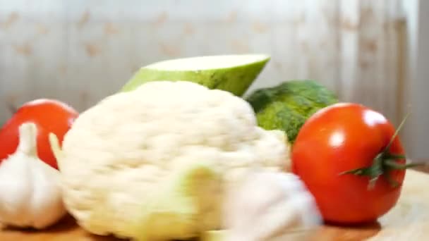 Bloemkool, courgette, tomaat, broccoli en knoflook, draaien op een houten snijplank. 4k. — Stockvideo