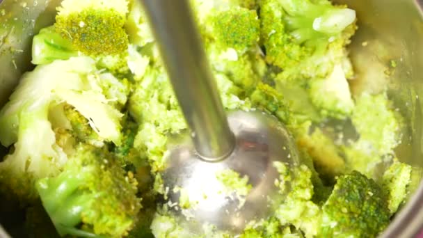Alguien hace puré de brócoli con una licuadora de manos. Primer plano, cámara lenta, 4k. espacio de copia — Vídeo de stock