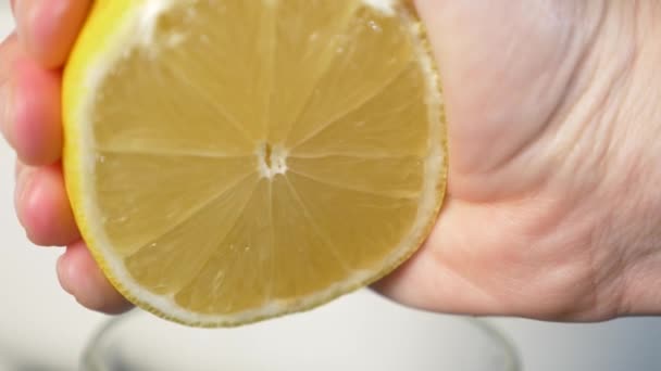 4k, slow-motion, close-up. hand compressing lemon. squeeze out lemon juice — Stock Video