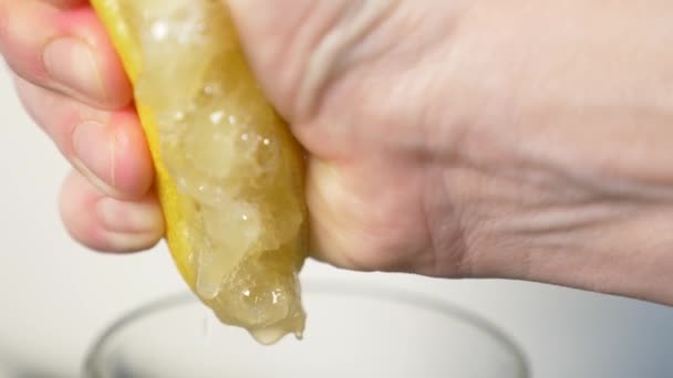 4k, slow-motion, close-up. hand compressing lemon. squeeze out lemon juice — Stock Video