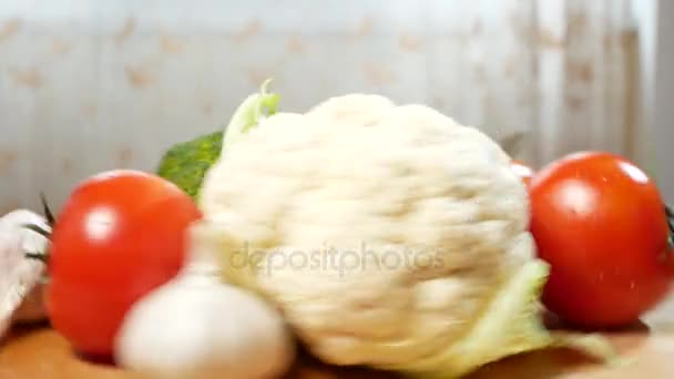 Cauliflower, tomatoes, broccoli and garlic, rotating on a wooden cutting board. 4k. — Stock Video