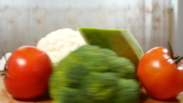 Couve-flor, abobrinha, tomate, brócolis e alho, girando sobre uma tábua de corte de madeira. 4k . — Vídeo de Stock