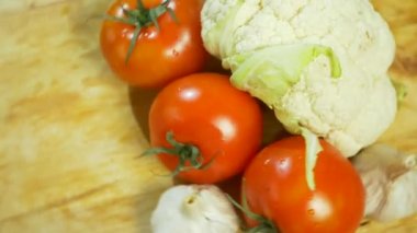 karnabahar ve üç domates ahşap kesme tahtası üzerinde iplik. 4k