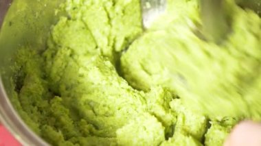 Biri brokoli bir El blender ile püre yapar. yakın çekim, yavaş hareket, 4k. kopya alanı