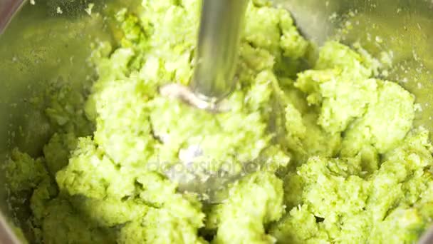 Alguém faz purê de brócolis com um liquidificador manual. close-up, câmera lenta, 4K. espaço de cópia — Vídeo de Stock