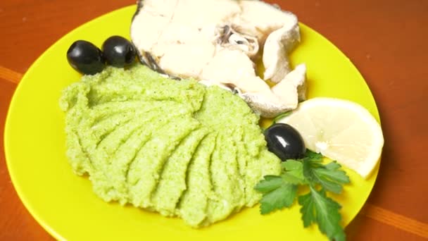 Iemand eet broccoli puree met gestoomde vis. 4k, slow-motion — Stockvideo