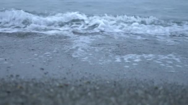 Playa de guijarros al atardecer. Las olas salpican y se rompen en gotitas. 4k, cámara lenta — Vídeos de Stock