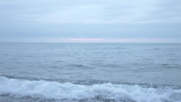 Playa de guijarros al atardecer. Las olas salpican y se rompen en gotitas. 4k, cámara lenta — Vídeos de Stock