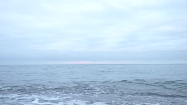 Playa de guijarros al atardecer. Las olas salpican y se rompen en gotitas. 4k, cámara lenta — Vídeos de Stock