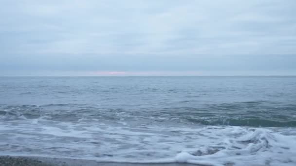 Гальковий пляж на заході сонця. Хвилі бризки і увірватися в краплі. 4 Кбайт, повільний рух — стокове відео