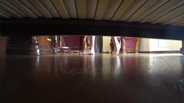 4k. female legs, view from under the bed. the jewelry fell under the bed. the necklace fell to the floor — Stock Video