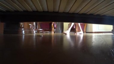 4 k. kadın bacakları, yatağın altından görüntüleyin. Takı yatağın altına düştü. bilezik düştüm. kadın düşmüş inci yükseltir