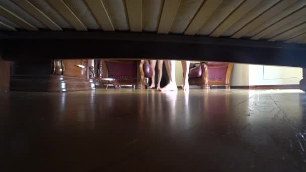 4k, kvinnliga och manliga fötter Visa från under sängen. man och kvinna kommer in i sovrummet — Stockvideo