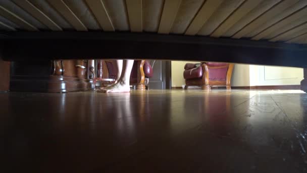 4k, female legs view from under the bed. a woman in a robe opens the door and exits the bedroom — Stock Video