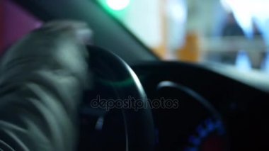 A günbatımında bir araba el sürücüler şehirde mans. büyük bir şehir ışıkları. arka plan bulanıklık. 4k