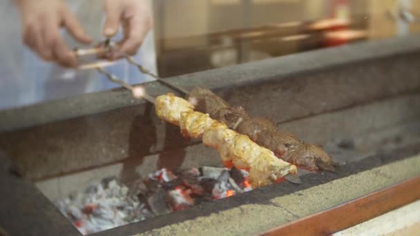 Smaker shish kebab på grill. Kokken lager en shish kebab på grillen. 4k . – stockvideo