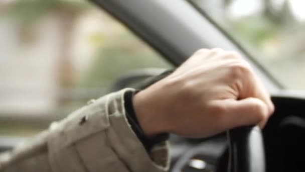 A mans hand drives a car at sunset in the city. lights of a big city. background blur. 4k — Stock Video