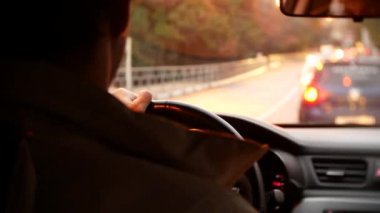 A günbatımında bir araba el sürücüler şehirde mans. büyük bir şehir ışıkları. arka plan bulanıklık. 4k