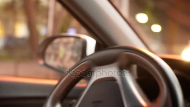 Un hombre conduce un coche al atardecer en la ciudad. luces de una gran ciudad. fondo borroso. 4k — Vídeos de Stock