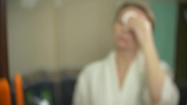 Smutsiga används bomullstuss med spår av makeup. Kvinna rengöring ansikte med bomullspinne framme av spegeln. 4k, slowmotion. närbild. bakgrundsoskärpa. — Stockvideo