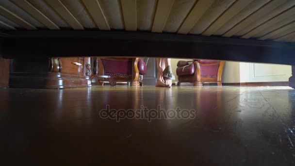 4k, kvinnliga ben, Visa från under sängen. en kvinna tar av sina strumpor och ligger ner på sängen — Stockvideo