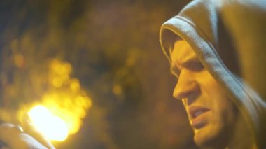 Kukuletalı adam profili cep telefonu arıyorum. yakın çekim, arka plan bulanıklık, bokeh. 4k