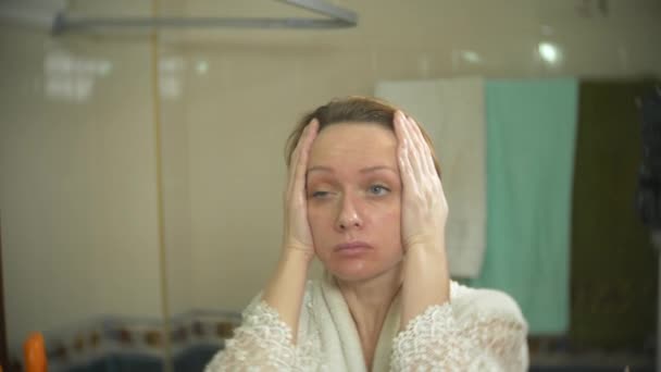 A woman is washing her face in front of a mirror. 4k, slow motion. close-up. background blur. — Stock Video