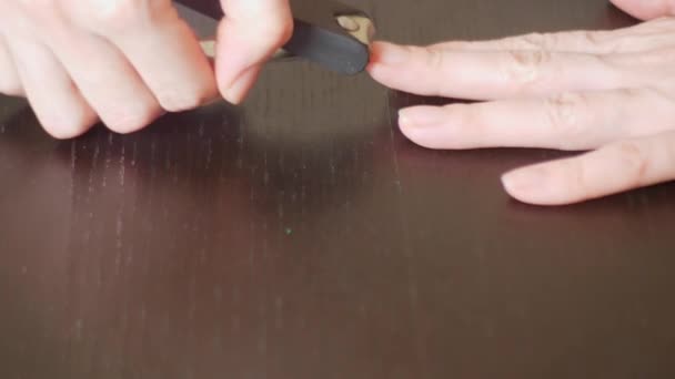 Manicura femenina del brazo de cerca. Cortar clavos. una mujer hace una manicura con un cortaúñas. 4k, primer plano, cámara lenta — Vídeos de Stock
