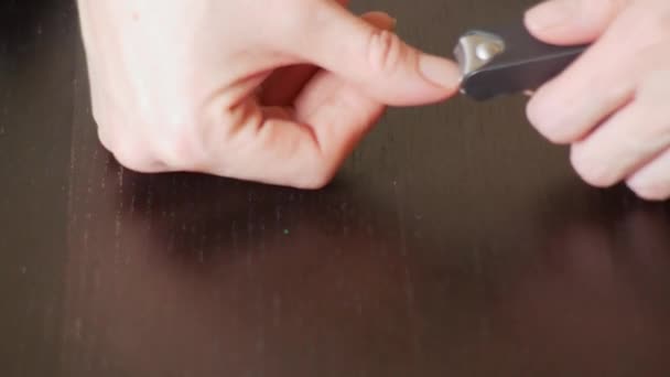 Manucure féminine du bras rapproché. Couper des ongles. une femme fait une manucure avec une tondeuse à ongles. 4k, gros plan, ralenti 