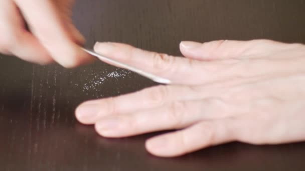Маникюр Живопись ногтей. Женщина отпиливает ногти на тёмном деревянном столе. 4k, крупный план, замедленная съемка — стоковое видео