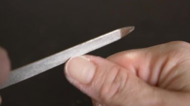Resim tırnaklar manikür. bir kadının tırnaklarını koyu ahşap bir masa üzerinde kapalı testereleri. 4 k, yakın çekim, ağır çekim