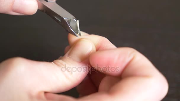 Mains féminines manucure vue rapprochée. Coupe les bavures. une femme se fait une manucure à l'aide de coupe-ongles. 4k, gros plan, ralenti 
