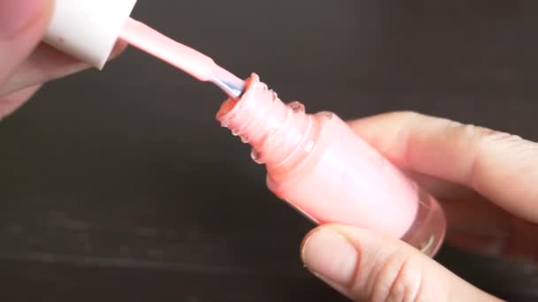 Женщина красит ногти розовым лаком. 4k, крупный план, замедленная съемка — стоковое видео