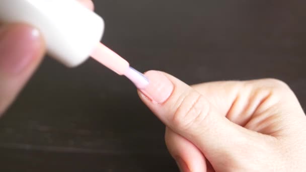 Kvinnan målar naglarna med rosa nagellack. 4k, närbild, slow motion — Stockvideo