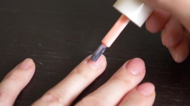 Kadın tırnaklarını pembe ojeyle boyuyor. 4k, yakın çekim, yavaş çekim