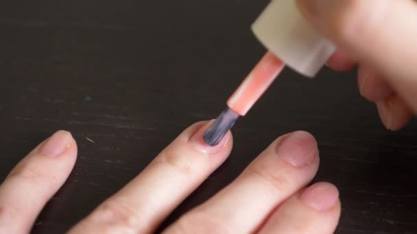 Mujer pintándose las uñas con esmalte de uñas rosa. 4k, primer plano, cámara lenta — Vídeo de stock