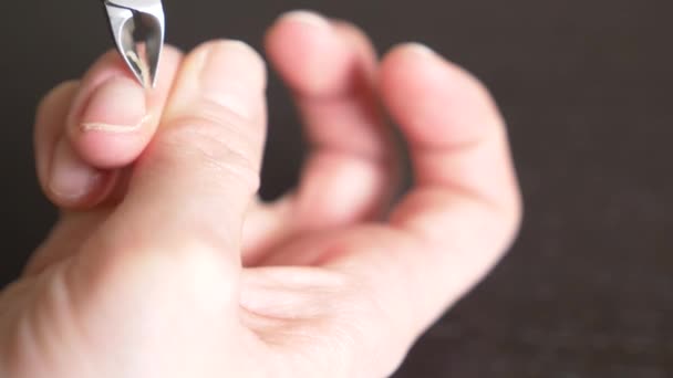 Mains féminines manucure vue rapprochée. Coupe les bavures. une femme se fait une manucure à l'aide de coupe-ongles. 4k, gros plan, ralenti 