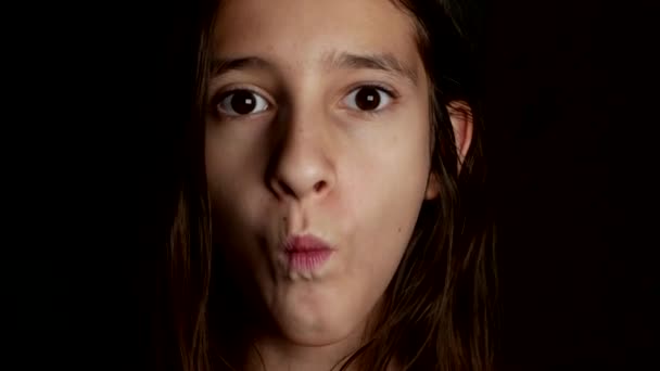 Közelről. egy vidám tizenéves lány veszi a száj nagy kerek candy, hasonló a szemében. 4k. — Stock videók
