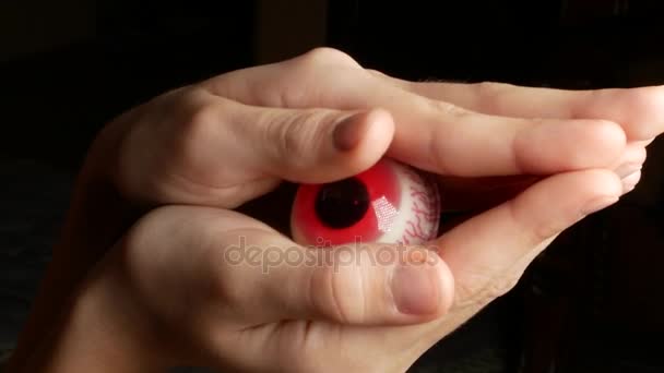 Close-up. Someone hides in the palms of large round candy, similar to the eyes. 4k. — Stock Video