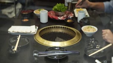 Bulgogi, restoranda Korece Barbekü yiyecek. Barbekü, 4 k, yakın çekim ızgara masada Çin restoranında yemek
