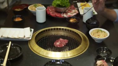 Bulgogi, restoranda Korece Barbekü yiyecek. Barbekü, 4 k, yakın çekim ızgara masada Çin restoranında yemek