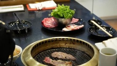 Bulgogi, restoranda Korece Barbekü yiyecek. Barbekü, 4 k, yakın çekim ızgara masada Çin restoranında yemek