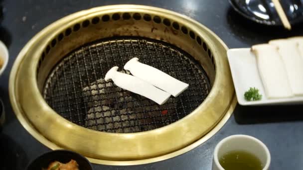 Еда в булгоги, корейское барбекю, в ресторане. приготовление пищи в китайском ресторане на столе гриль барбекю, 4k, крупный план — стоковое видео